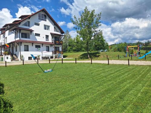 a large yard with a house and a playground at Casa ARRA in Bran