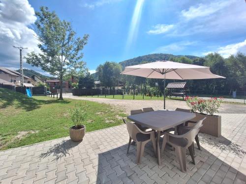 a table and chairs with an umbrella on a patio at Casa ARRA in Bran