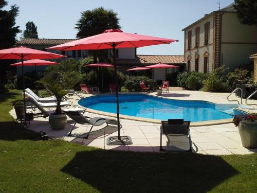 - une piscine avec des chaises et des parasols à côté dans l'établissement GUTKOWSKI Jacqueline, à Saint-Philbert-de-Bouaine