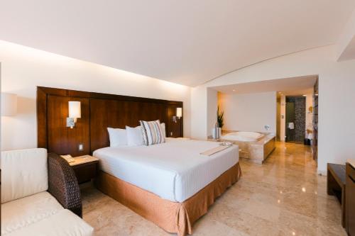 a bedroom with a large bed and a bath tub at Azul Ixtapa Grand All Inclusive Suites - Spa & Convention Center in Ixtapa