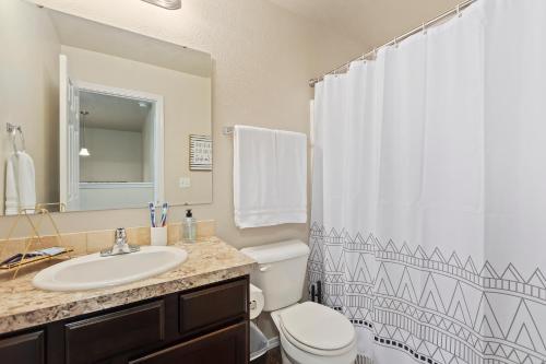 a bathroom with a sink and a toilet and a shower curtain at Massage Chair, Pool, Sleep Number Bed, Location in Meridian