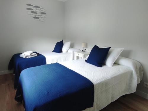 2 camas en una habitación de color azul y blanco en Ortegal Beach & Seacliffs, en Cariño