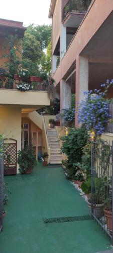 a building with a green courtyard with stairs and plants at Elisa e Carla House Beautiful apartments on the Cassia in Rome