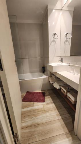 ein Badezimmer mit einer Badewanne, einem Waschbecken und einem Spiegel in der Unterkunft Fabuloso departamento con todo y cerca de todo in Buenos Aires
