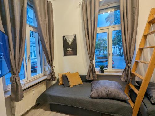 Bett in einem Zimmer mit 2 Fenstern in der Unterkunft Schönes Apartment am Rhein - Zentral 1 in Koblenz