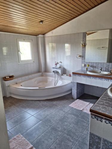 een grote witte badkamer met een bad en een wastafel bij House Near Airport Pallini Metro Station in Pallíni