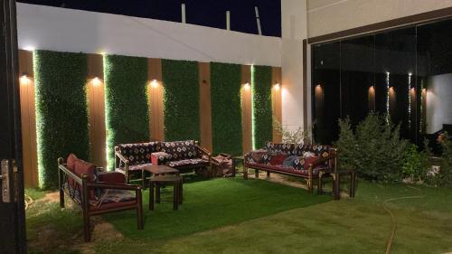 un soggiorno con divani e parete verde di شاليه اند هوم a Hail