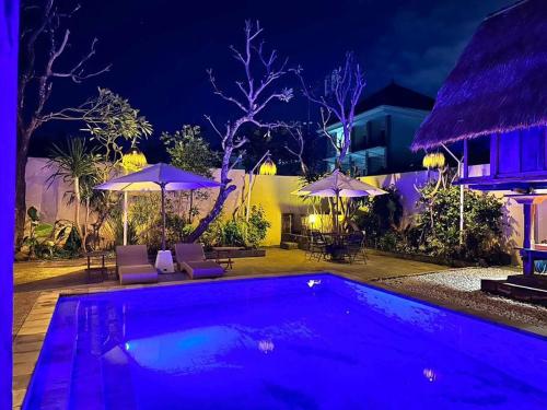 a swimming pool at night with umbrellas at kuta 5BR private villa pool ,near airport, in Kuta
