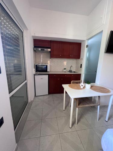 a small kitchen with a white table and a table at Electra Studios in Palaiochora