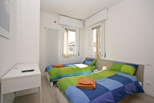 two beds in a small room with a desk and a bed sidx sidx sidx sidx at Venice Residence Elisabeth in Mestre