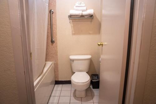 a bathroom with a toilet and a tub and towels at Americas Best Value Inn Lynnwood in Lynnwood