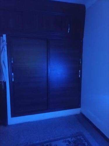 Ain sbaa Hay mohmmadi في الدار البيضاء: غرفة مظلمة بها خزانة ملابس بباب أسود