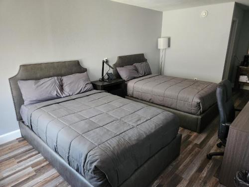 a bedroom with two beds and a table with a lamp at Heritage Place Hotel in Iuka