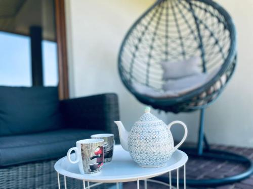 a table with two cups and a vase on it at Green Hill House in Pępice