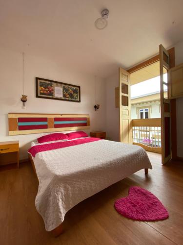 a bedroom with a large bed with red pillows at Hostal Don Jose in Santa Rosa de Cabal