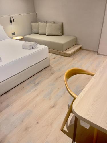 a room with two beds and a couch and a table at Andon Lapa Hotel & Spa in Sarandë