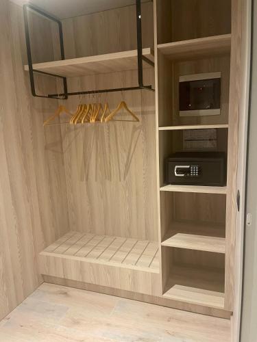 a walk in closet with a cabinet with a microwave at Andon Lapa Hotel & Spa in Sarandë