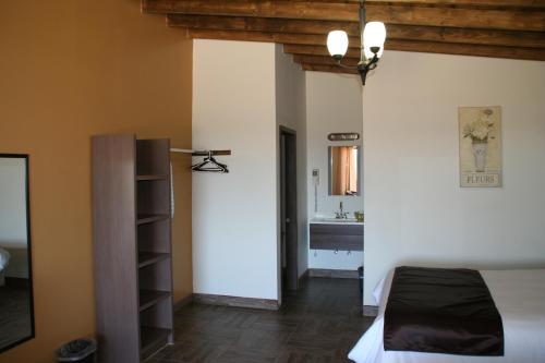 a bedroom with a bed and a bathroom at Quinta Sofia Valle de Guadalupe in Valle de Guadalupe