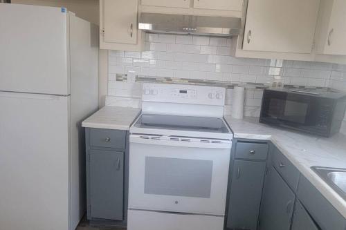 a kitchen with a white stove and a microwave at Quiet 3 bed with fenced yard in Columbus