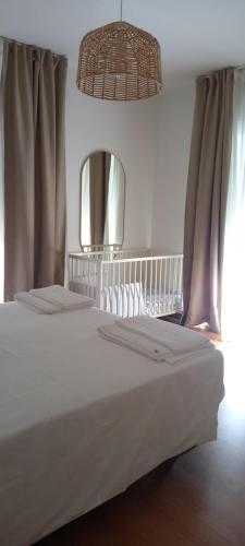 a bedroom with a large white bed with a mirror at Casa da Praia - Manta Rota in Manta Rota