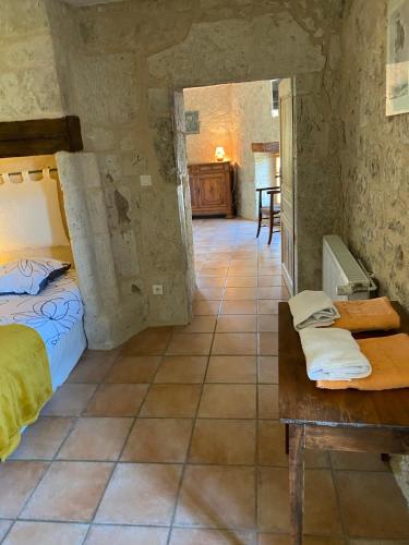 une chambre avec un lit et une table dans une pièce dans l'établissement Gîte La Maison du Bonheur, à Dondas