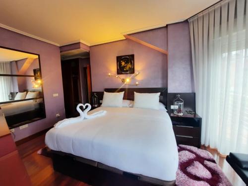 a bedroom with a large white bed and a television at !Chalet de lujo para vacaciones!... in Camargo