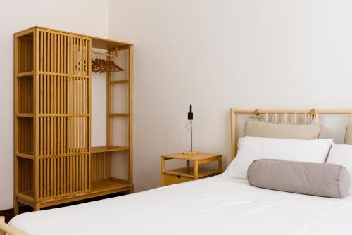 a bedroom with a white bed and a book shelf at B&D Dolce Vita in Rome