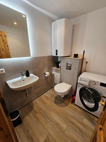 a bathroom with a sink and a washing machine at Natur- und Aktivresort Senftenberg in Schipkau