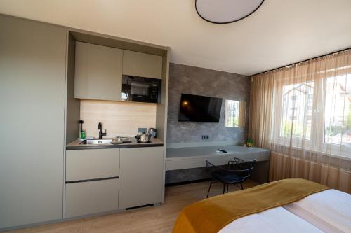 a bedroom with a bed and a sink and a kitchen at V Business Apartments Böblingen in Böblingen
