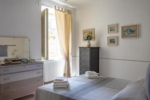 - une chambre avec un lit, une commode et une fenêtre dans l'établissement Casa vacanze nel centro storico di Fermo Happy Song, à Fermo