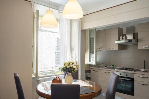 a kitchen with a table with a vase of flowers on it at Casa vacanze nel centro storico di Fermo Happy Song in Fermo