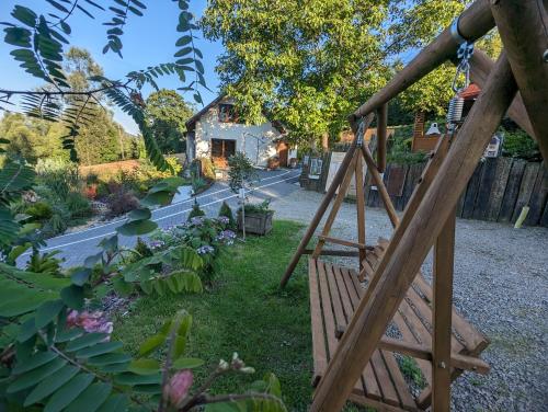 a garden with a wooden swing in a yard at Makowy domek in Maków Podhalański