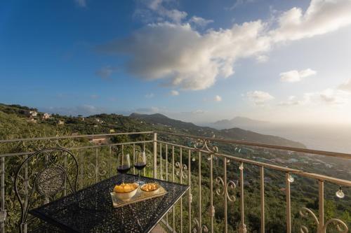 a balcony with a table with two glasses of wine at Al Calar del Sole in Massa Lubrense