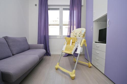 a living room with a couch and a yellow high chair at Venice Residence Elisabeth in Mestre