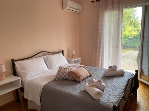 una camera da letto con due asciugamani su un letto con finestra di Vanilla Holiday House ad Alepoú