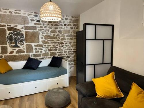 ein Wohnzimmer mit einem Bett und einer Couch in der Unterkunft Appartement neuf 4pers, remparts in Guérande