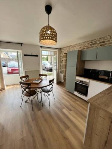 une cuisine et une salle à manger avec une table et des chaises dans l'établissement Appartement neuf 4pers, remparts, à Guérande