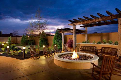 a fire pit in a patio with chairs and a pergola at Courtyard by Marriott Jackson in Jackson