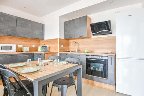 La Canebière - Appart 2 chambres avec terrasse في مارسيليا: مطبخ مع طاولة وكراسي وثلاجة بيضاء
