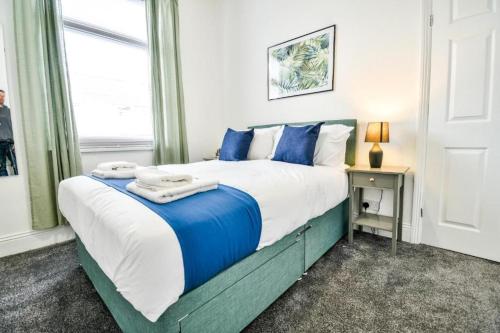a bedroom with a large bed with blue pillows at Lister House in Hartlepool