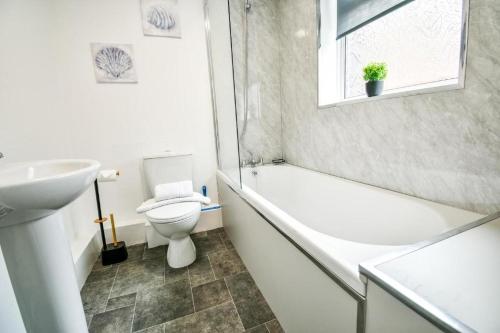 a bathroom with a toilet and a sink and a bath tub at Lister House in Hartlepool