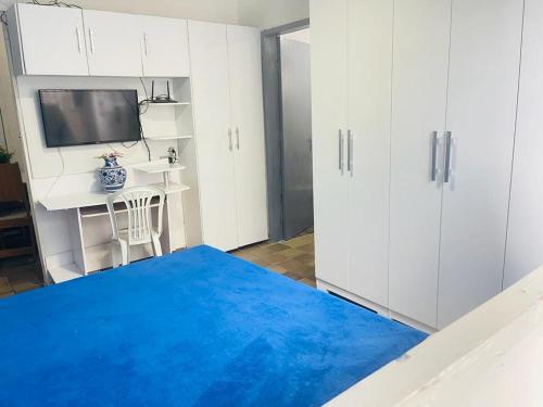 uma sala de estar com um tapete azul e armários brancos em Apartamento em Boa Viagem no Recife