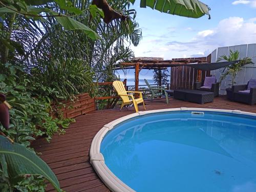 einen Pool auf einer Terrasse mit einem Tisch und Stühlen in der Unterkunft Enzo lodge chambre hibiscus in Papawa