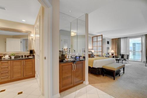 a hotel room with a bed and a bathroom at Premium Suite MGM Signature HIGH FLR Balcony Strip View in Las Vegas