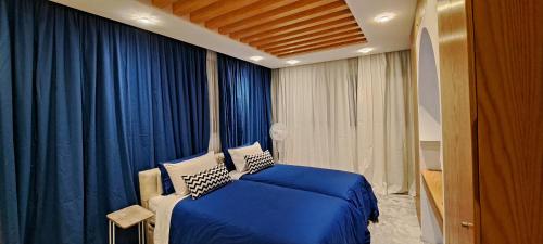 a bedroom with a blue bed and blue curtains at RABAT RESIDENCE in Rabat