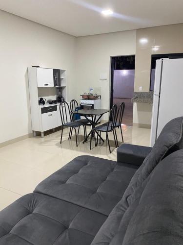 sala de estar con sofá, mesa y sillas en Flat Dona D - Prox da JK, en Palmas