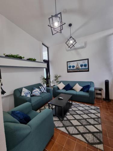 a living room with blue couches and a table at Casa Chelly Downtown Mérida in Mérida