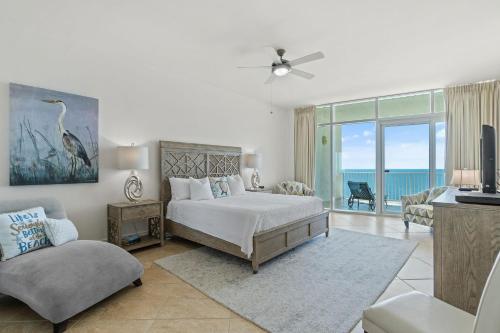 a bedroom with a bed and a balcony with the ocean at Turquoise C1706 in Orange Beach