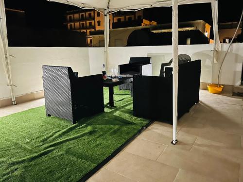 een kamer met een groen tapijt en een tafel met een paraplu bij I Bro casa vacanza in Marsala