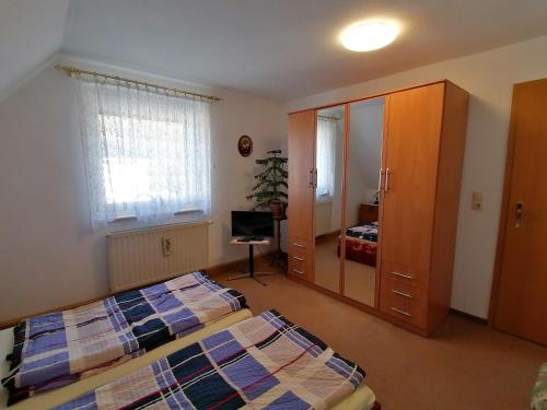 1 dormitorio con 2 camas y espejo en Haus am Waldrand, en Freital